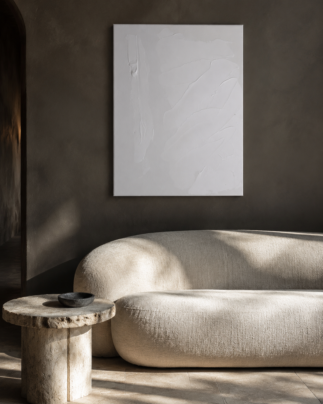 Space hung above a linen sofa in a warm plaster room