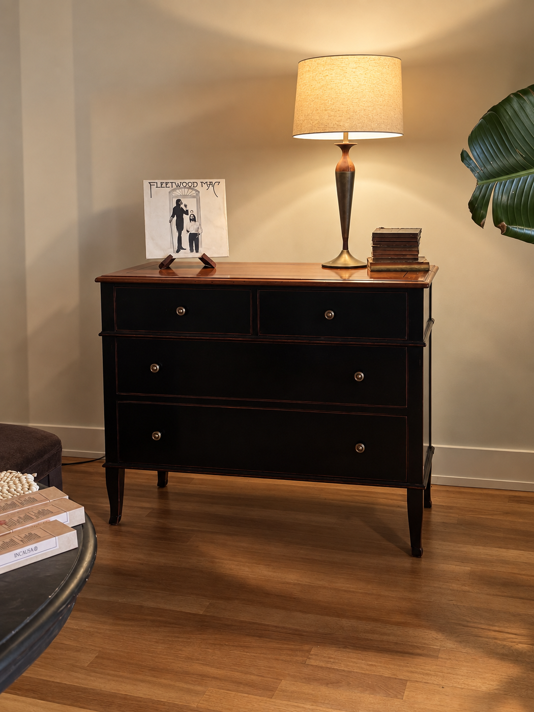 Theodore Alexander Atelier de Madeleine chest in black with cherry top, styled with a brass lamp and vintage books