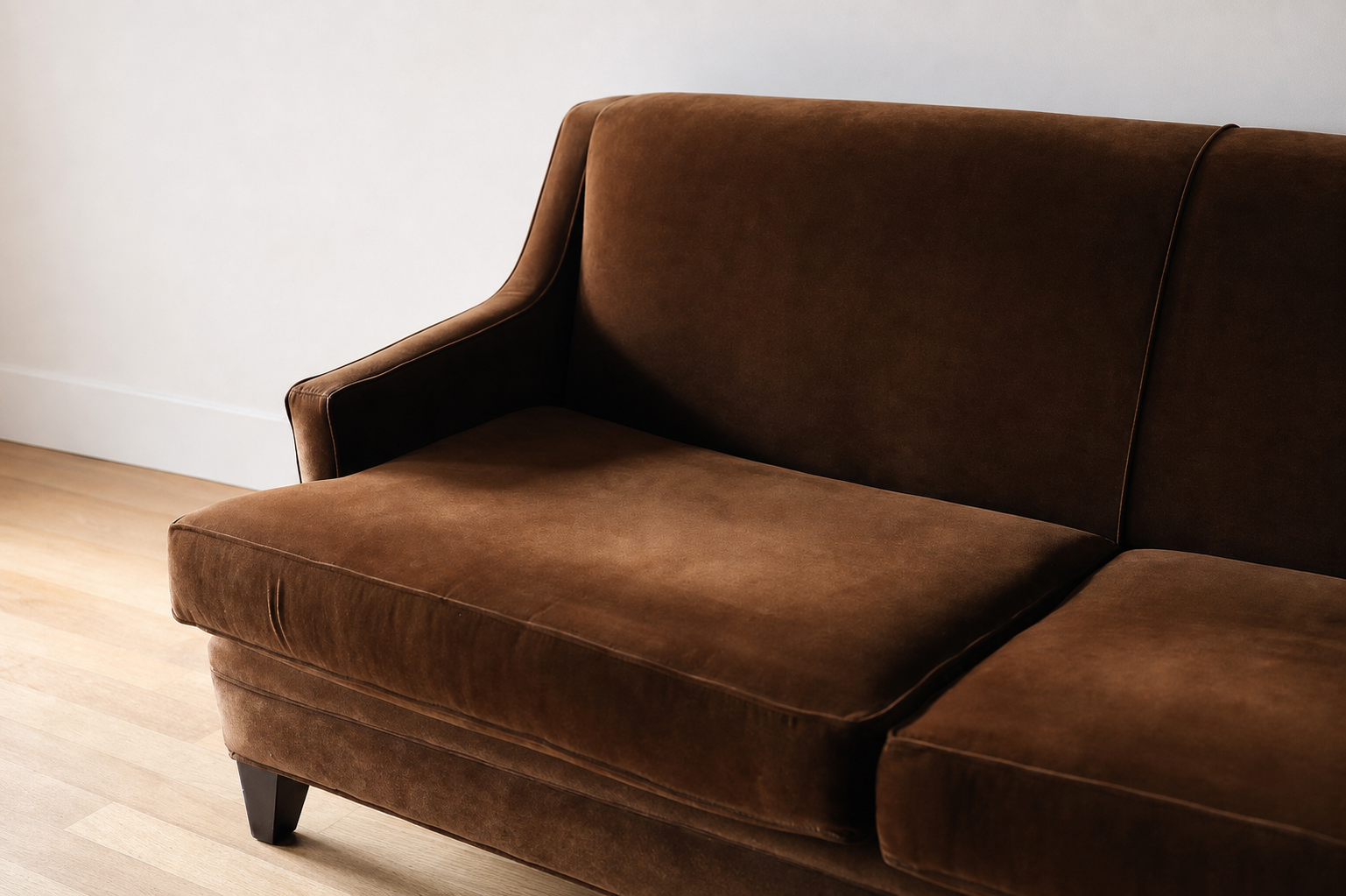 Detail of the cognac velvet arm and seat cushion with piped welting