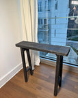 Ebonized reclaimed wood console, angled view showing leg splay