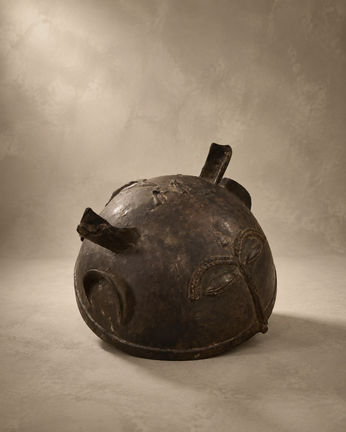 African Bronze Helmet, dark aged bronze dome with raised eye motifs and projecting horns