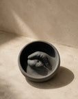 Lip Incense Holder in coal concrete, a lips form set in a round dish, on travertine