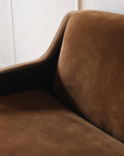 Close-up of the sloped arm and back corner in cognac velvet