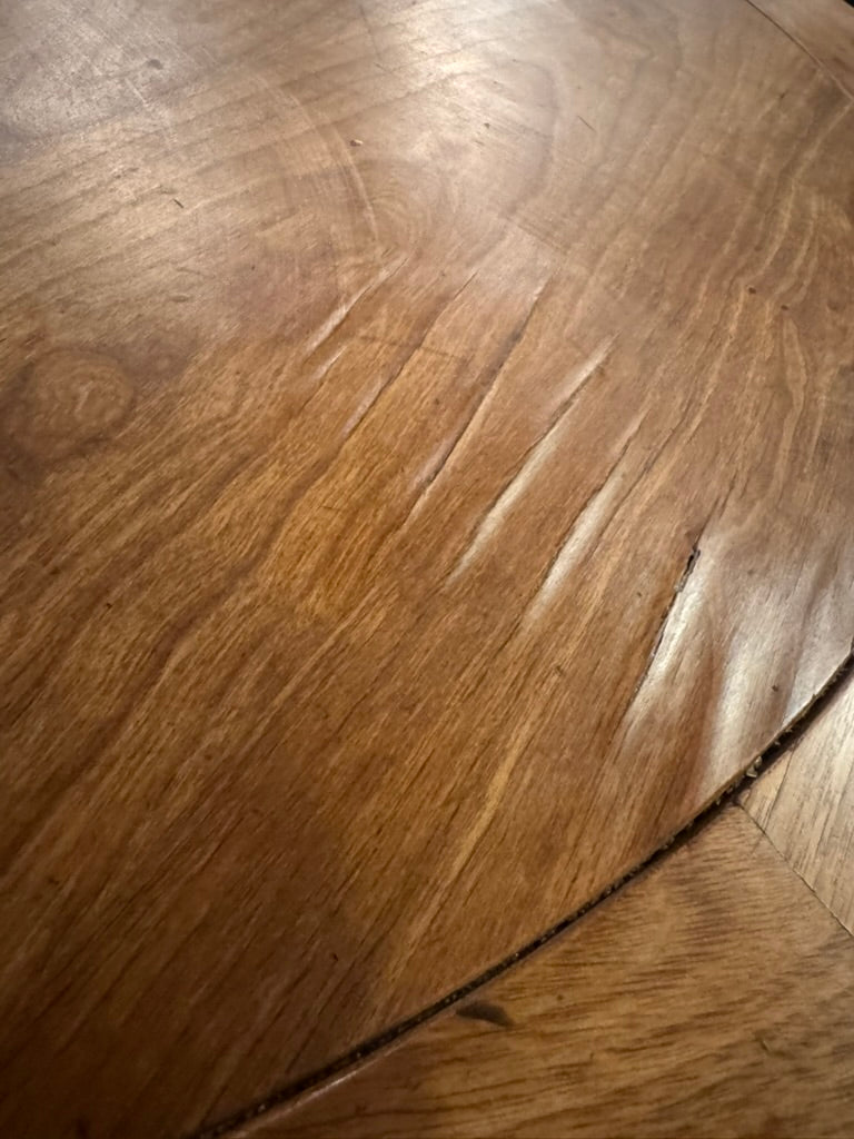 Real condition photo of the Aurelia tabletop showing small areas of lifting veneer near the inset banding