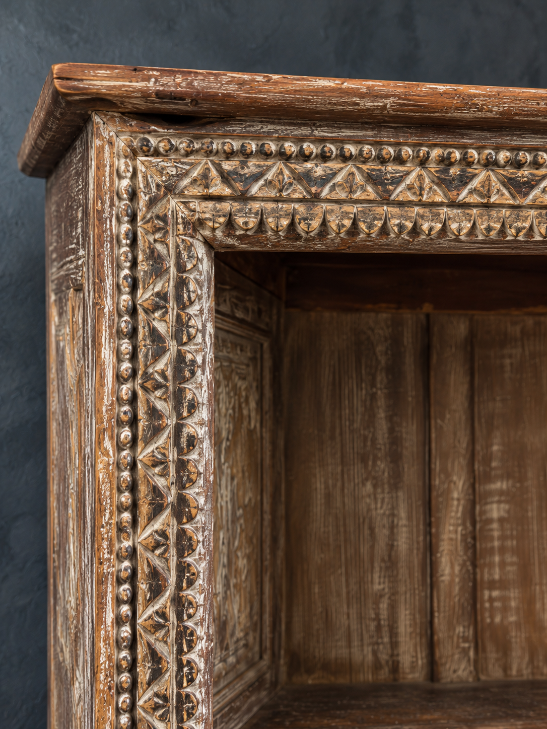 Close-up of the carved cornice and border with layered worn finish.