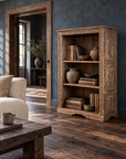 Carved bookcase in a reading room with slate walls and dark reclaimed floors.
