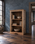 Carved bookcase beside a tall window on dark reclaimed wood flooring.