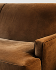 Cognac velvet back and arm detail beside a live-edge side table