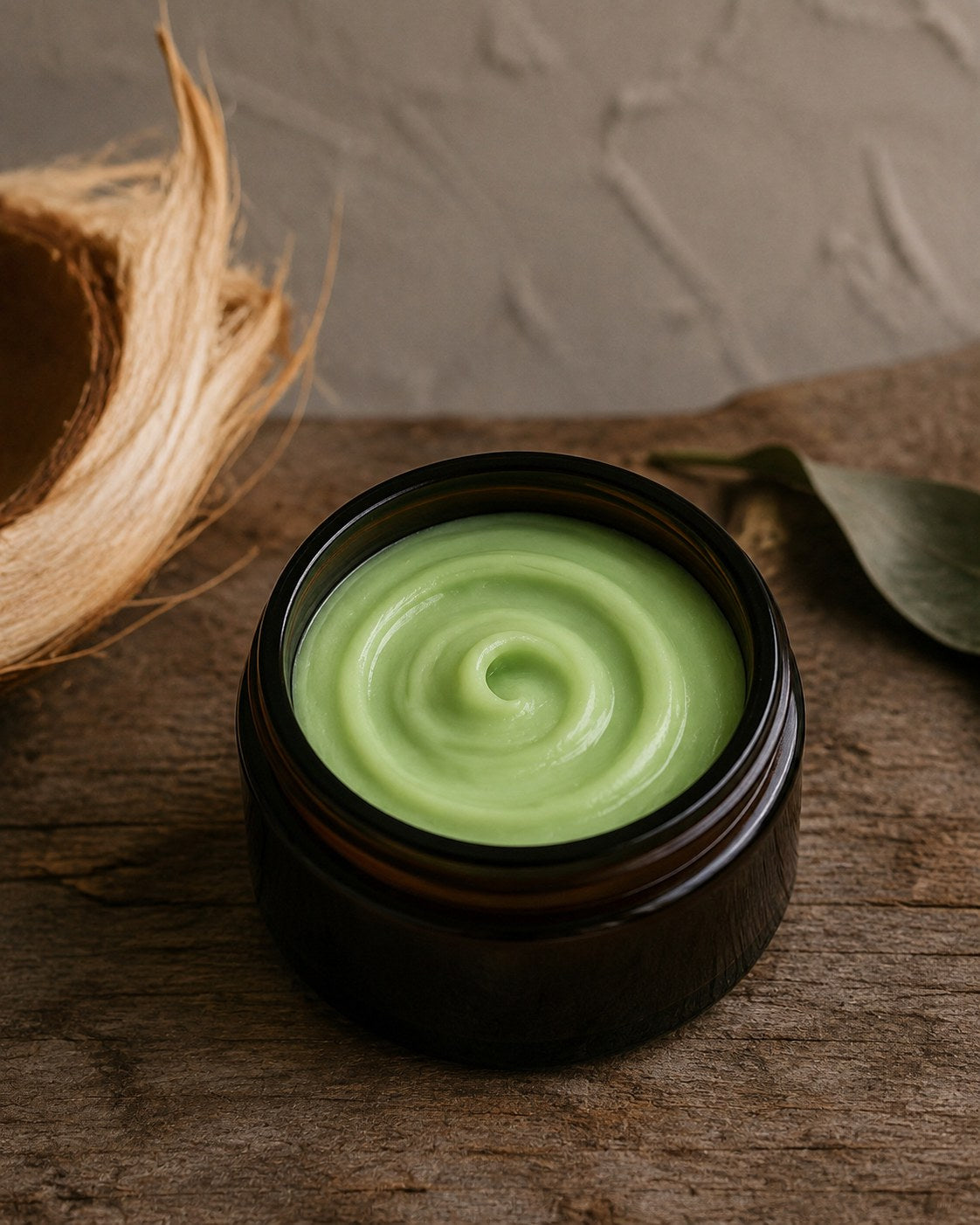 Green Coconut whipped body butter in an amber jar with coconut husk
