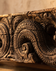 Close-up of the hand-carved scroll and wave carving