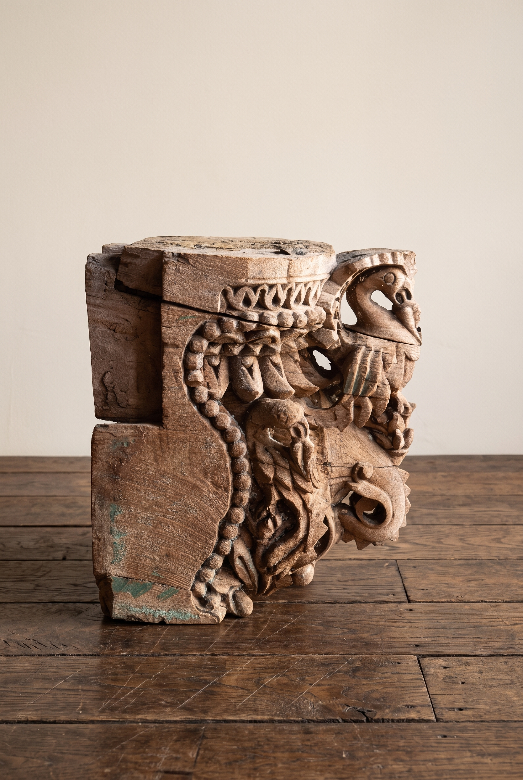 Carved teak temple capital, opposite profile showing a parrot bracket and foliage