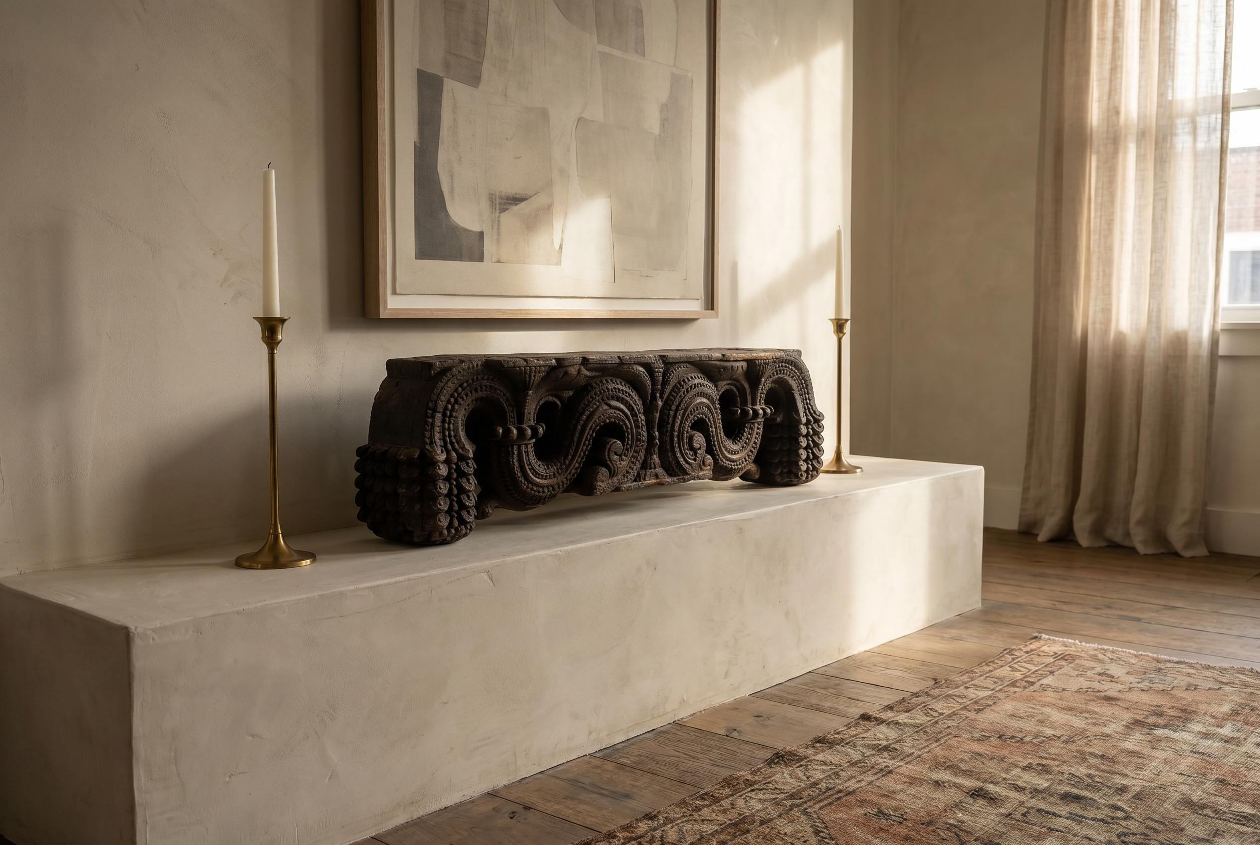 Antique carved wood piece on a plaster mantel beneath a large framed artwork