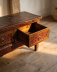 A drawer pulled open, showing the honest aged-wood interior