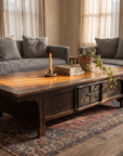 Antique low table surrounded by grey linen sofas