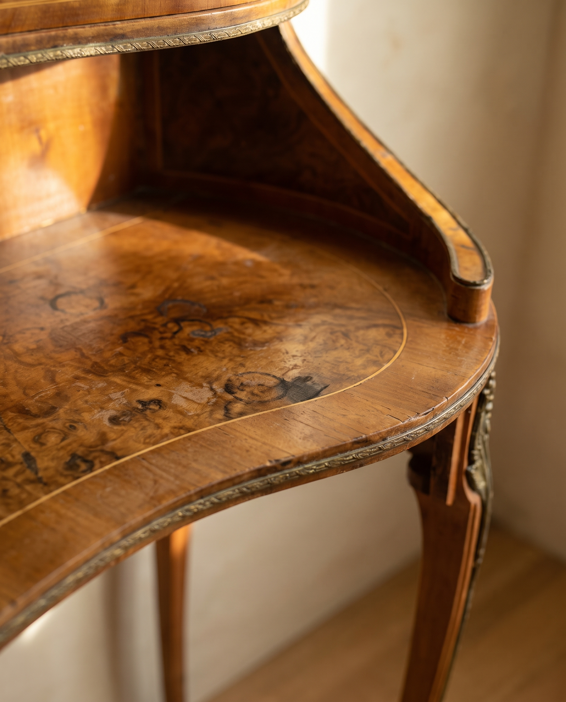 Close-up of the burled walnut writing surface with inlay and brass edge trim