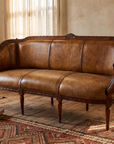 The Marea Settee, three-quarter view showing the carved frame and fluted legs