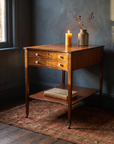 Antique mahogany bow-front two-drawer side table, candlelit hero