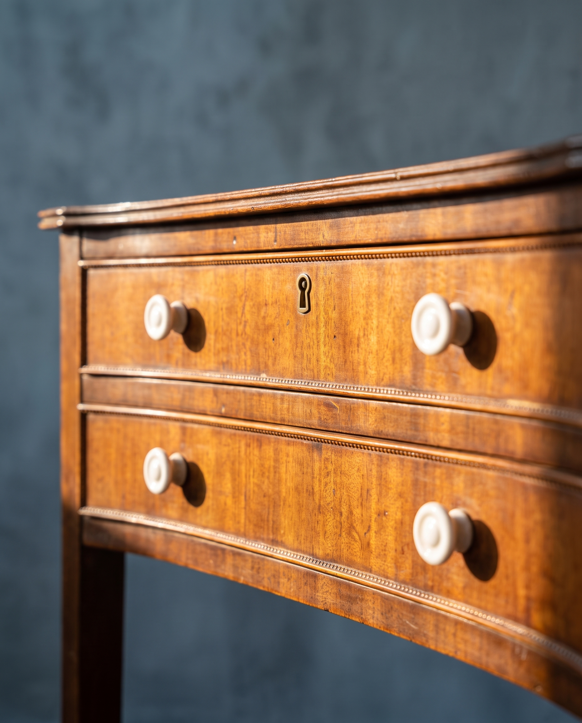 Detail of bow-front drawers, white porcelain knobs and brass keyhole