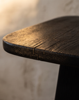 Macro detail of the charred wood grain and rounded edge of the Ember Side Table