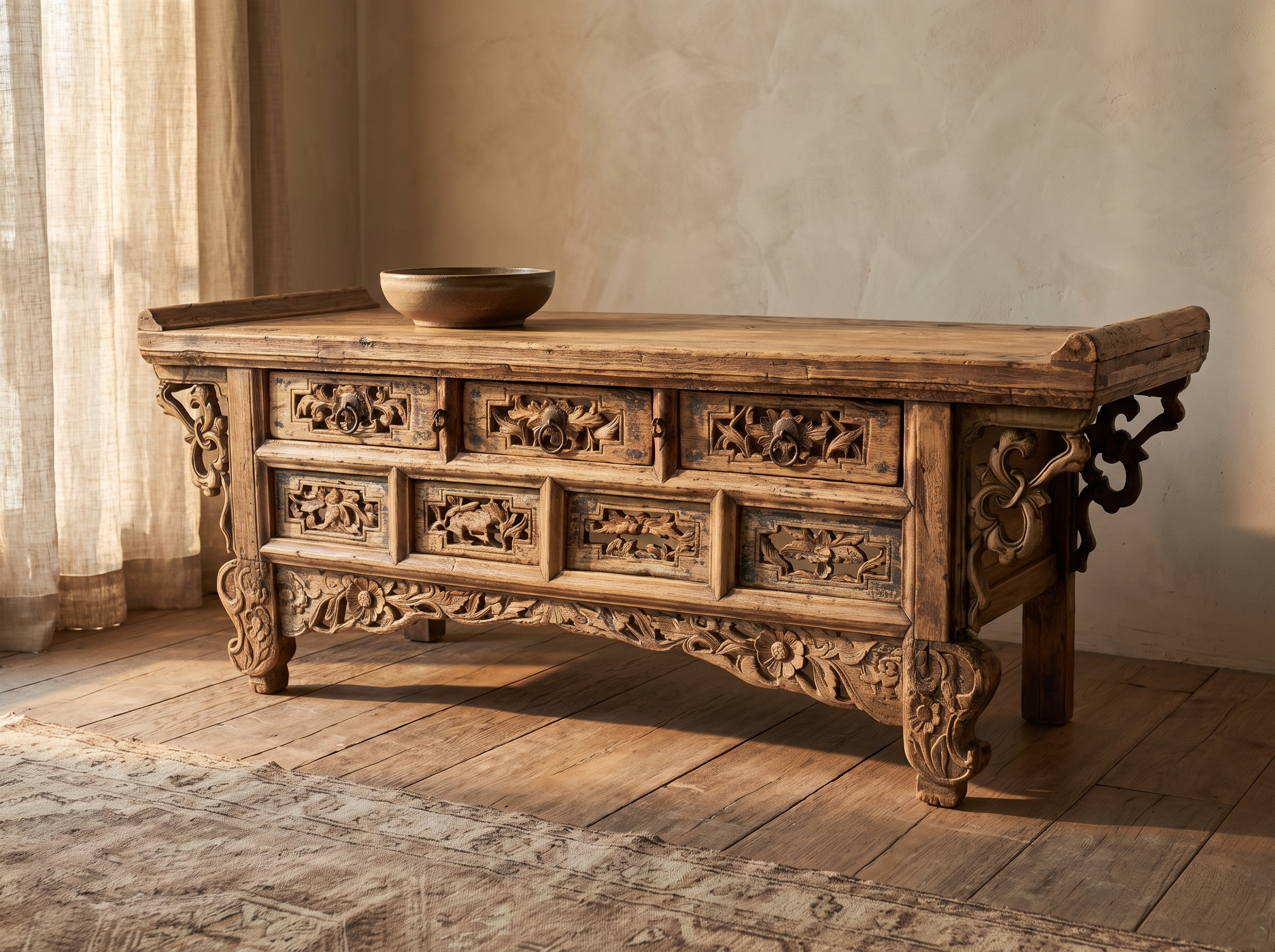 Front three-quarter view of the carved elm altar table in a warm plaster room