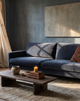 Navy velvet track-arm sofa in a warm, atmospheric living room