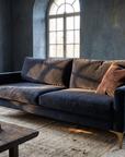 Navy velvet track-arm sofa, three-quarter view showing full form and construction