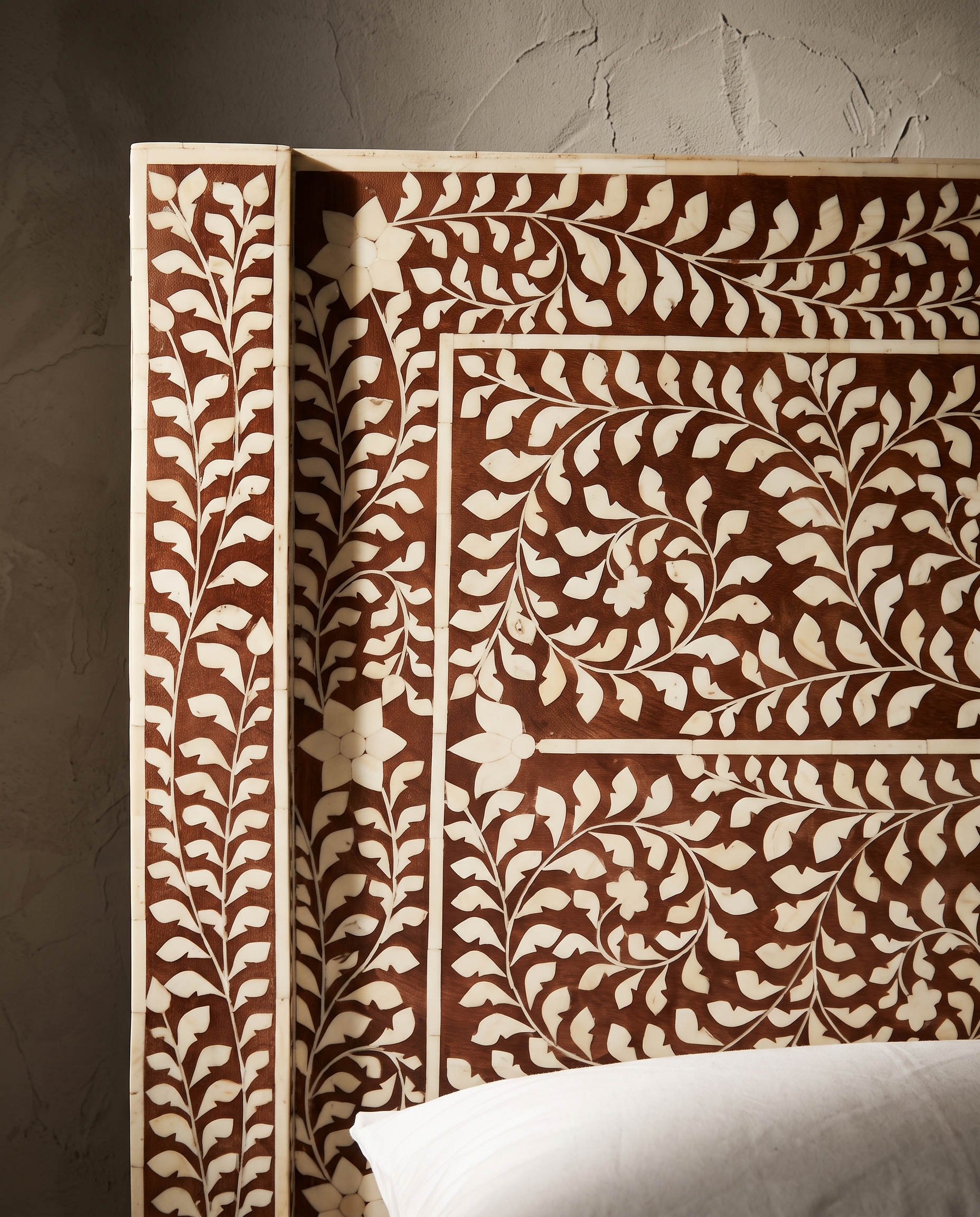 Macro detail of the hand-inlaid bone pattern on the headboard