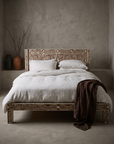 Bone Inlay Bed dressed in white linen bedding, in a greige plaster room