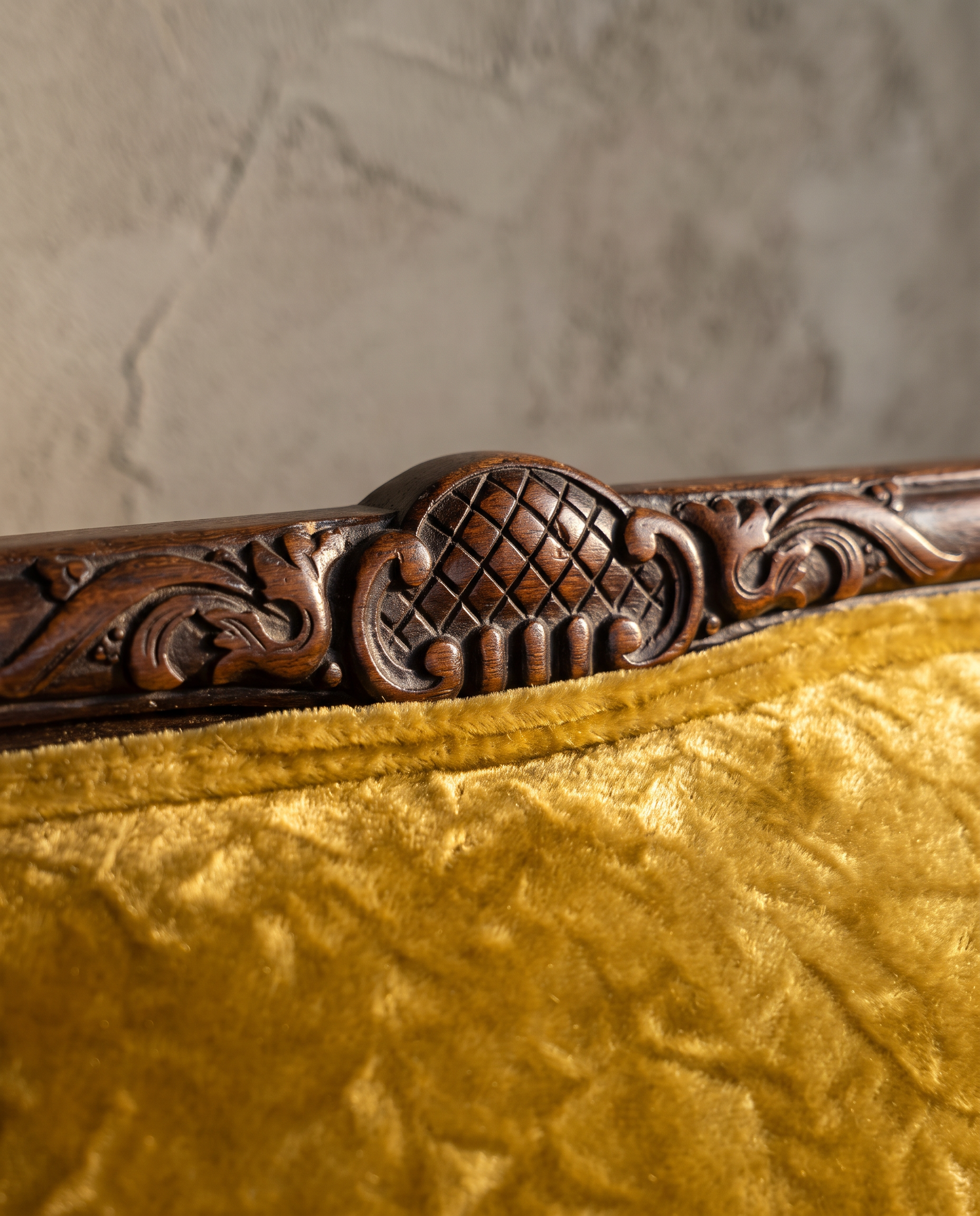 Macro detail of the hand-carved crest medallion and crushed gold velvet texture