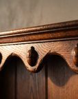 Detail of the carved acorn scallop valance on the antique oak dresser