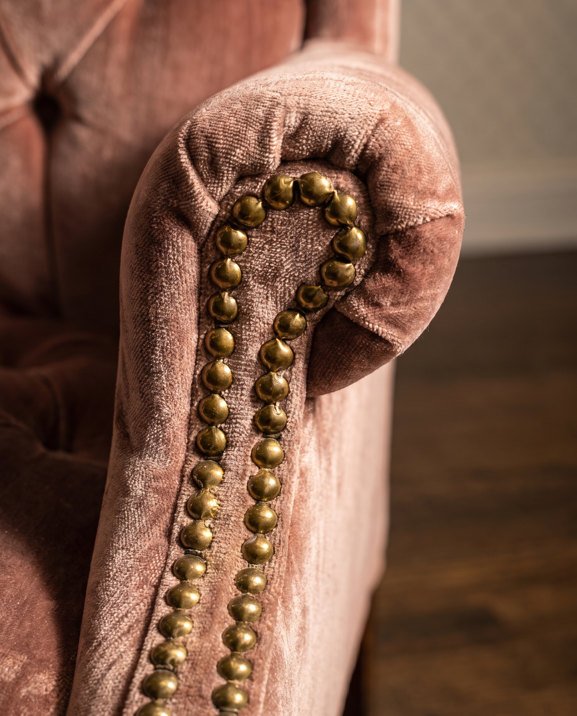 Macro detail of the rolled arm and double-row antique brass nailhead trim