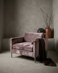 Smoked lilac velvet track-arm club chair, lifestyle shot in greige plaster room with draped chocolate linen