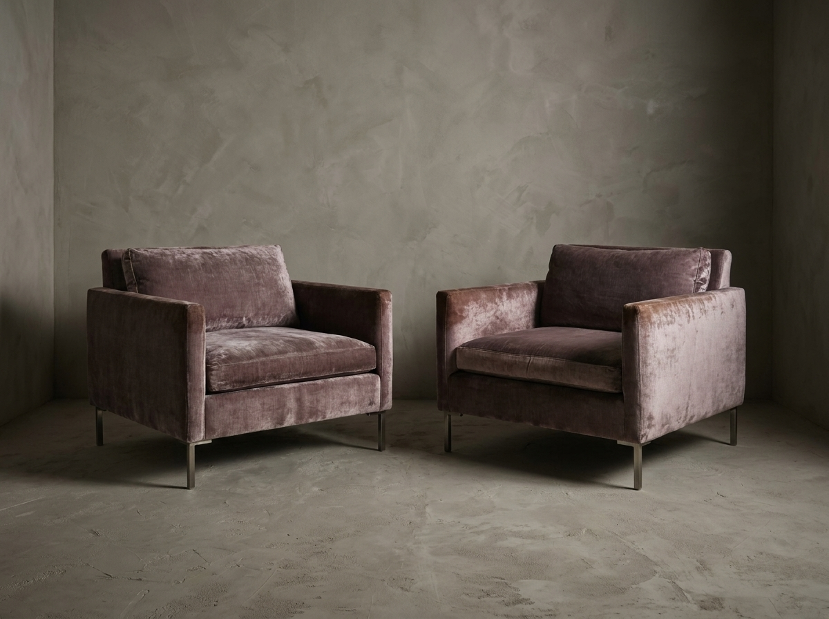 Pair of smoked lilac velvet track-arm club chairs side by side, front three-quarter view