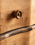 Second detail view of a turned wood knob and black distressed trim on The Curvy Dresser