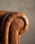 Macro detail of rolled scroll arm and pleated leather knuckle