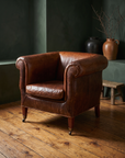 Vintage whiskey leather club chair, 45 degree three-quarter view showing full construction