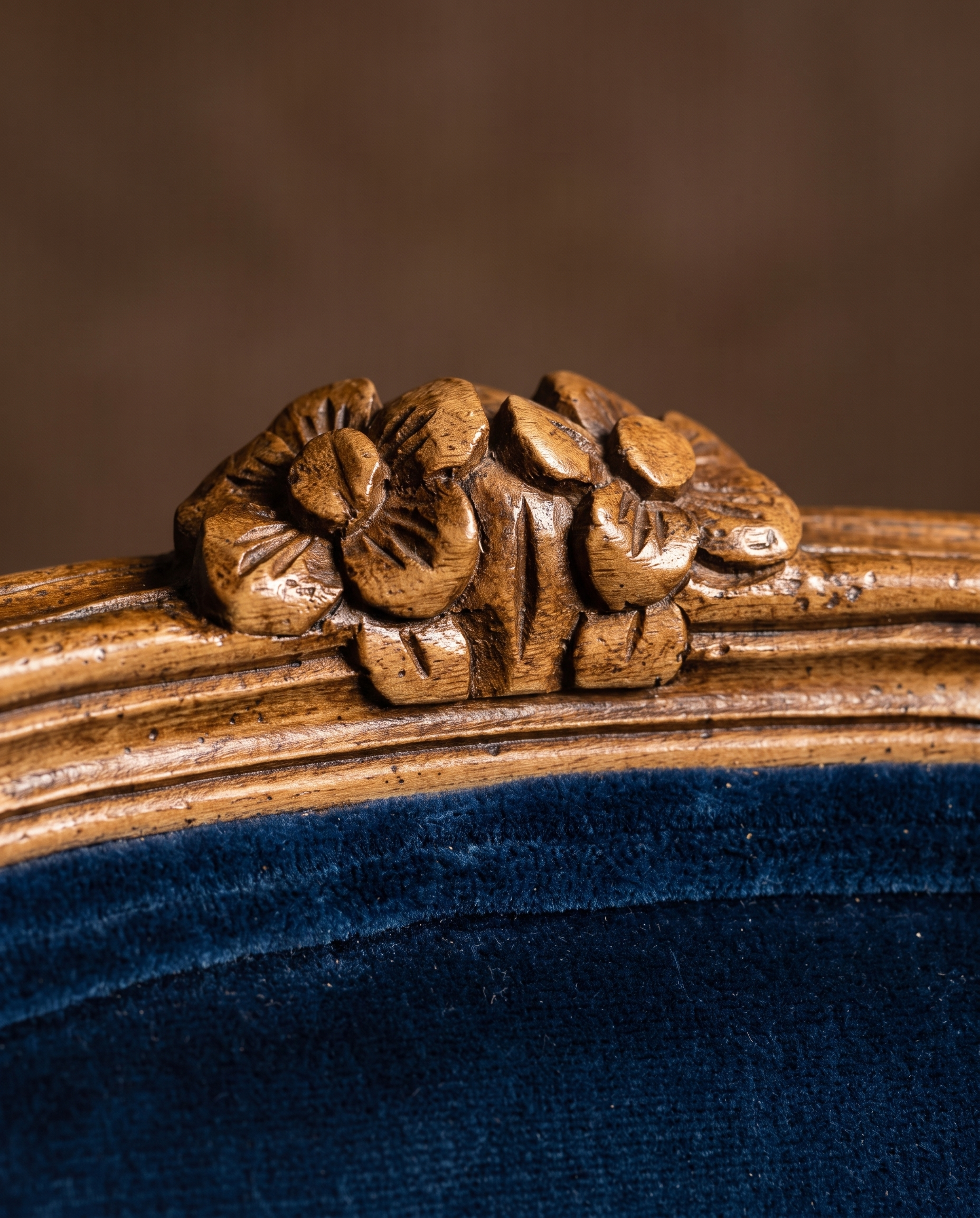 Detail of the two carved wooden flowers at the crest of the chair