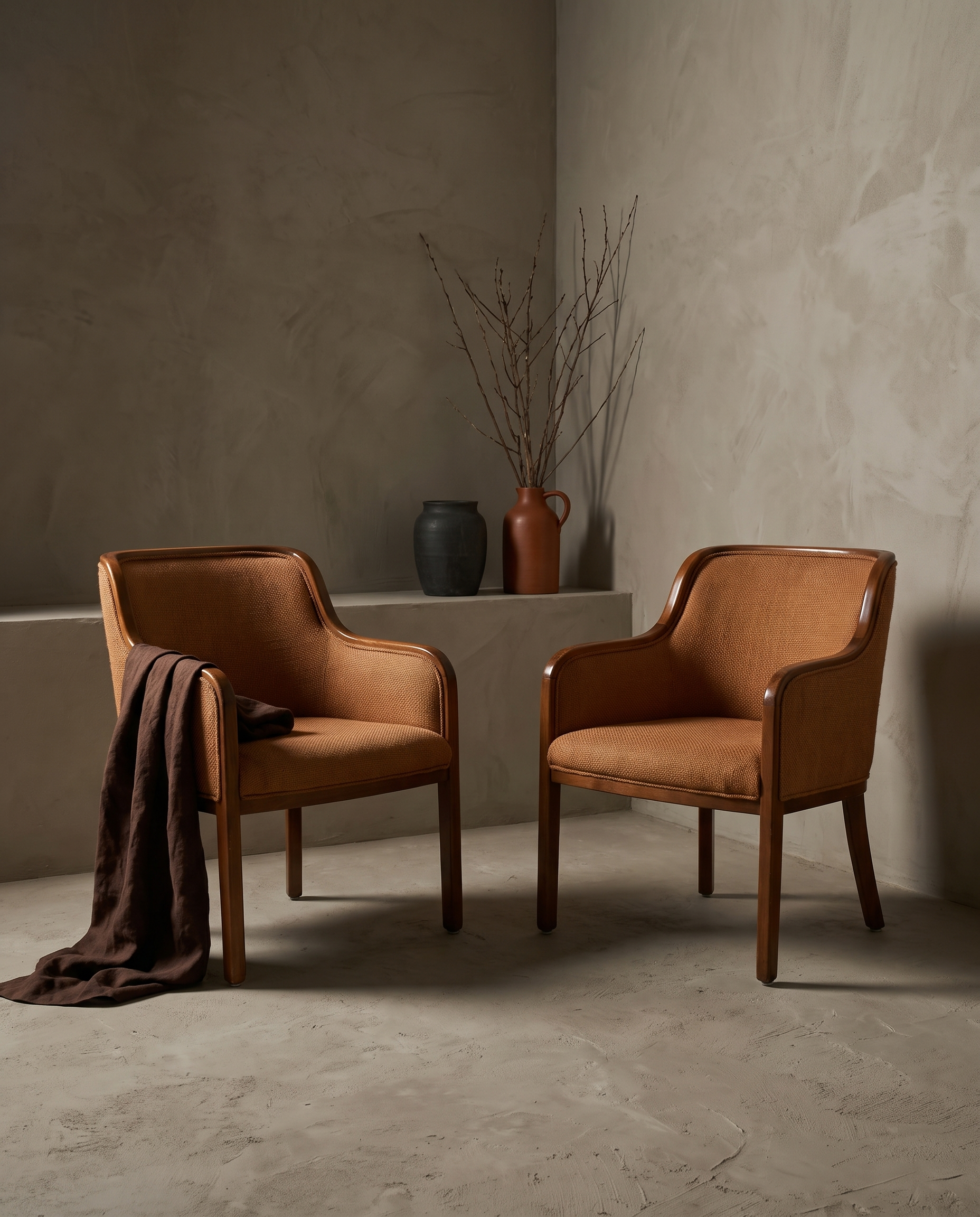 Pair of vintage burnt orange woven armchairs in an OE greige plaster room