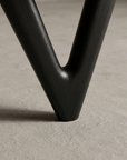 Close up detail of the black boomerang-shaped rear leg