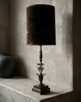 Alternate three-quarter view of the lamp against a troweled plaster wall in raking light
