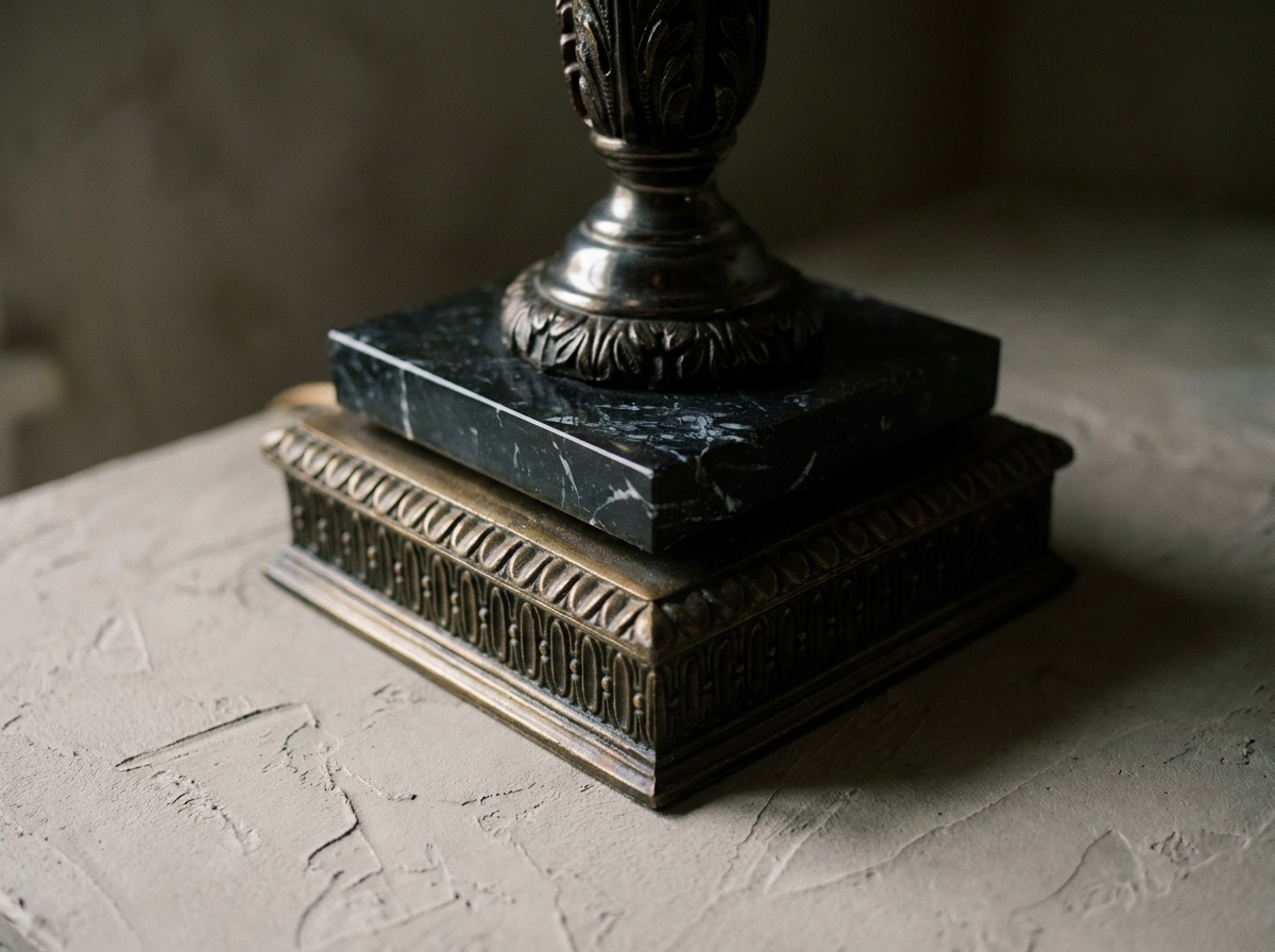 Macro detail of the black veined marble slab on the square bronze plinth with gadrooned moulding