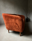 Outside back of the sofa showing the welt cord along the top edge, crushed velvet nap and slim tapered walnut legs
