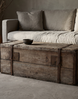 Antique pine trunk used as a coffee table in front of a linen sofa, greige plaster room