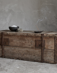 Antique pine trunk styled as a low altar stand with salt bowl, stone, and incense