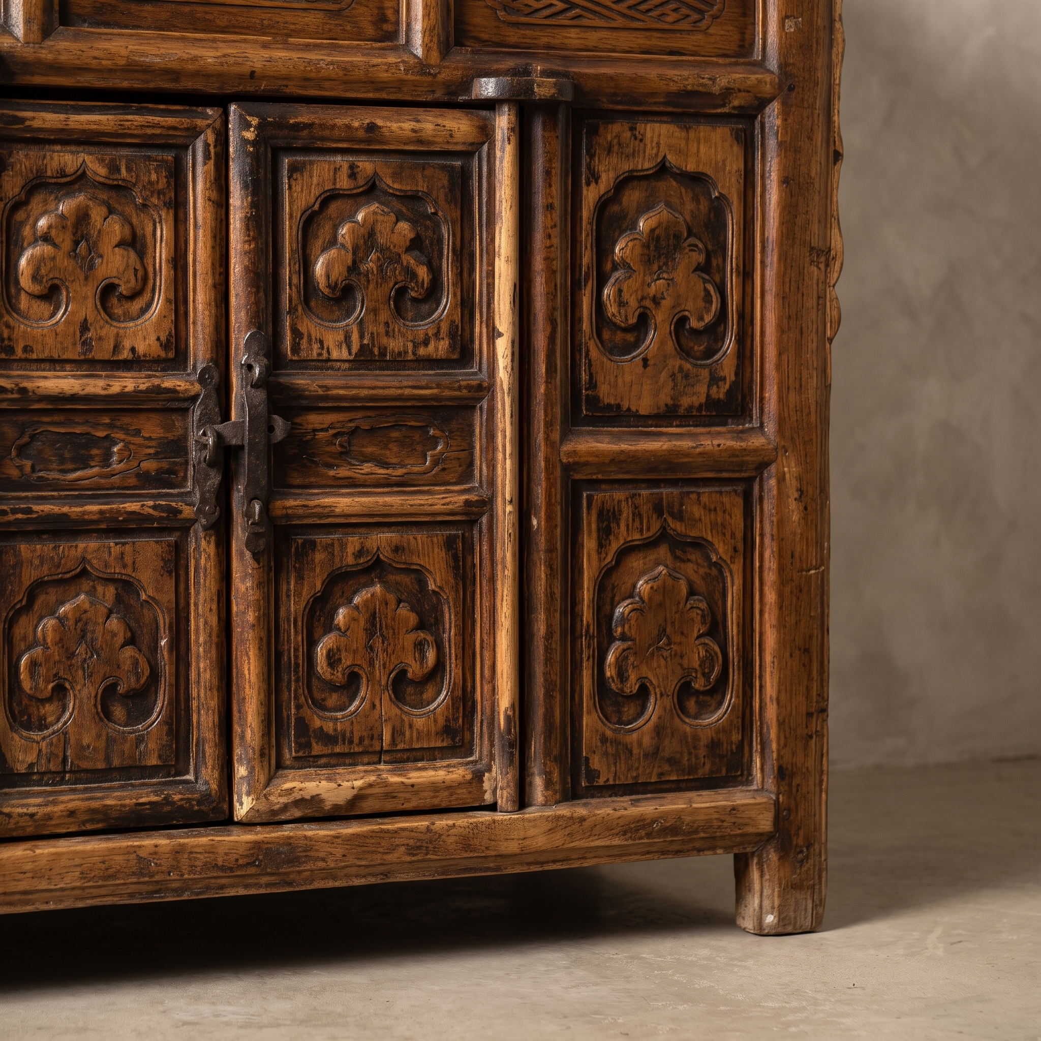 Macro detail of the cabinet doors, forged iron hasp, and carved medallion panels