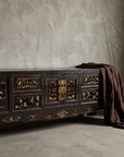 Antique Asian black lacquer console, three-quarter lifestyle view against a greige plaster wall