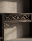 Macro detail of pierced fretwork rail between center cubbies