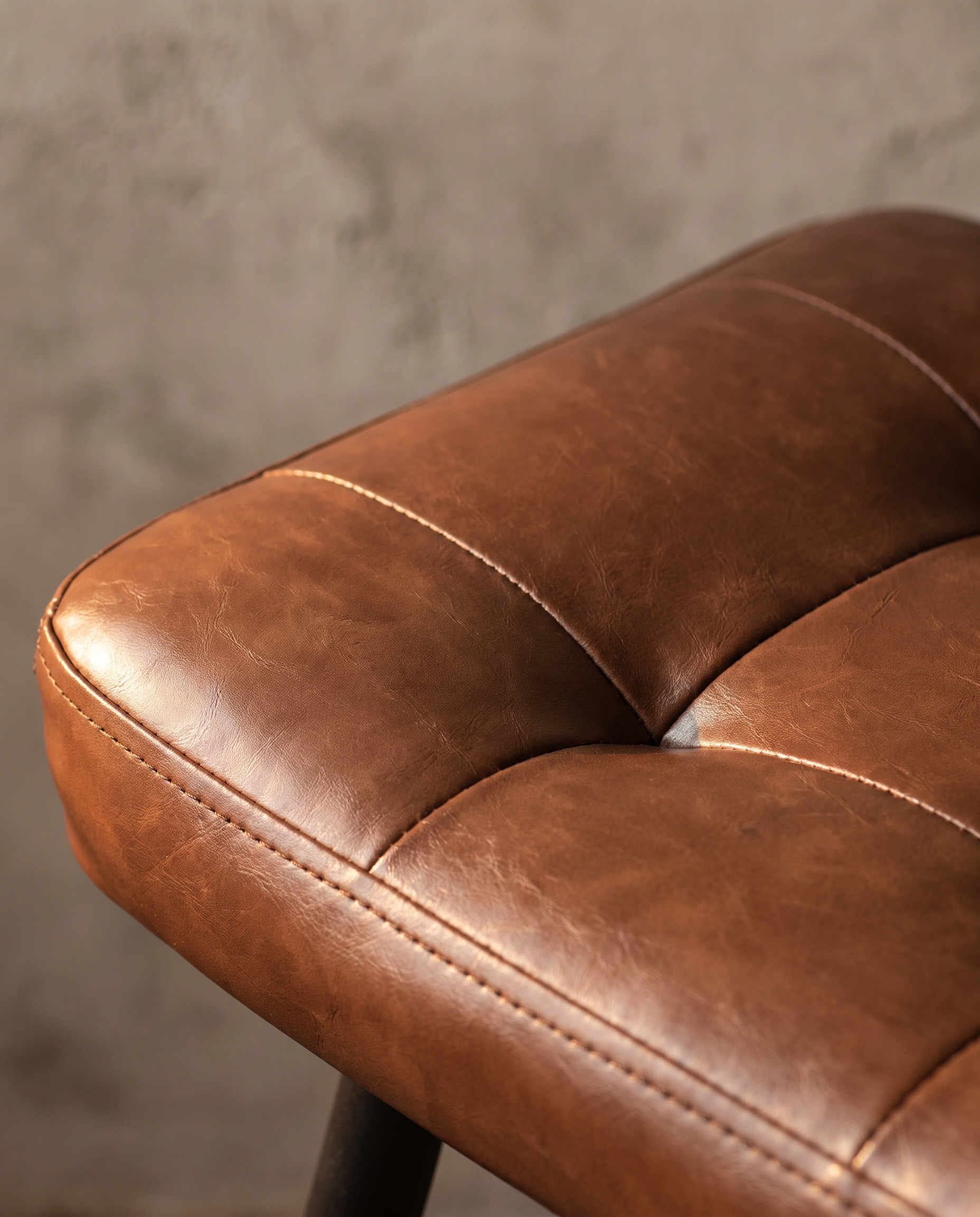 Macro detail of the diamond tufted cognac pleather seat