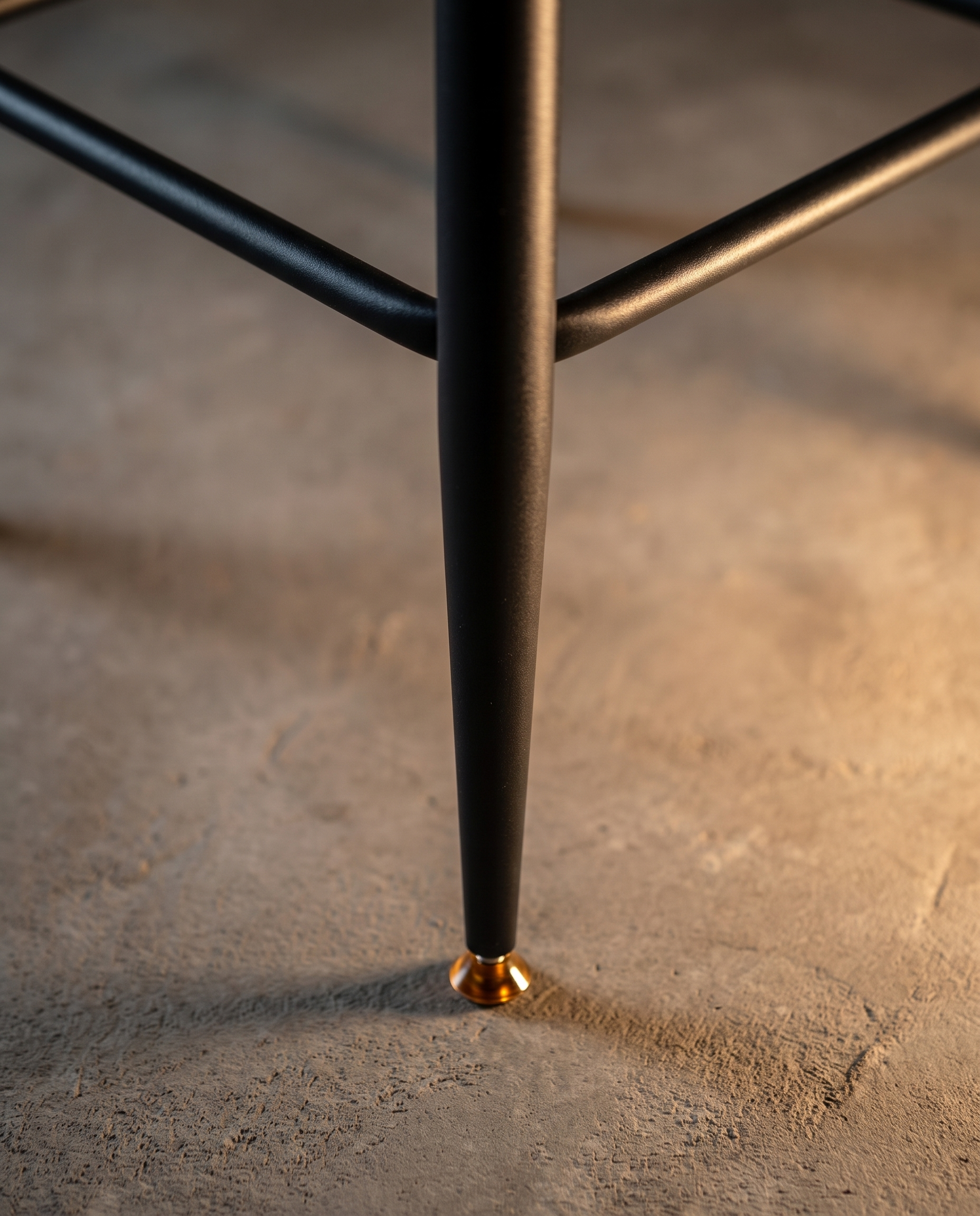 Alternate detail of the tapered black metal leg with brass glide