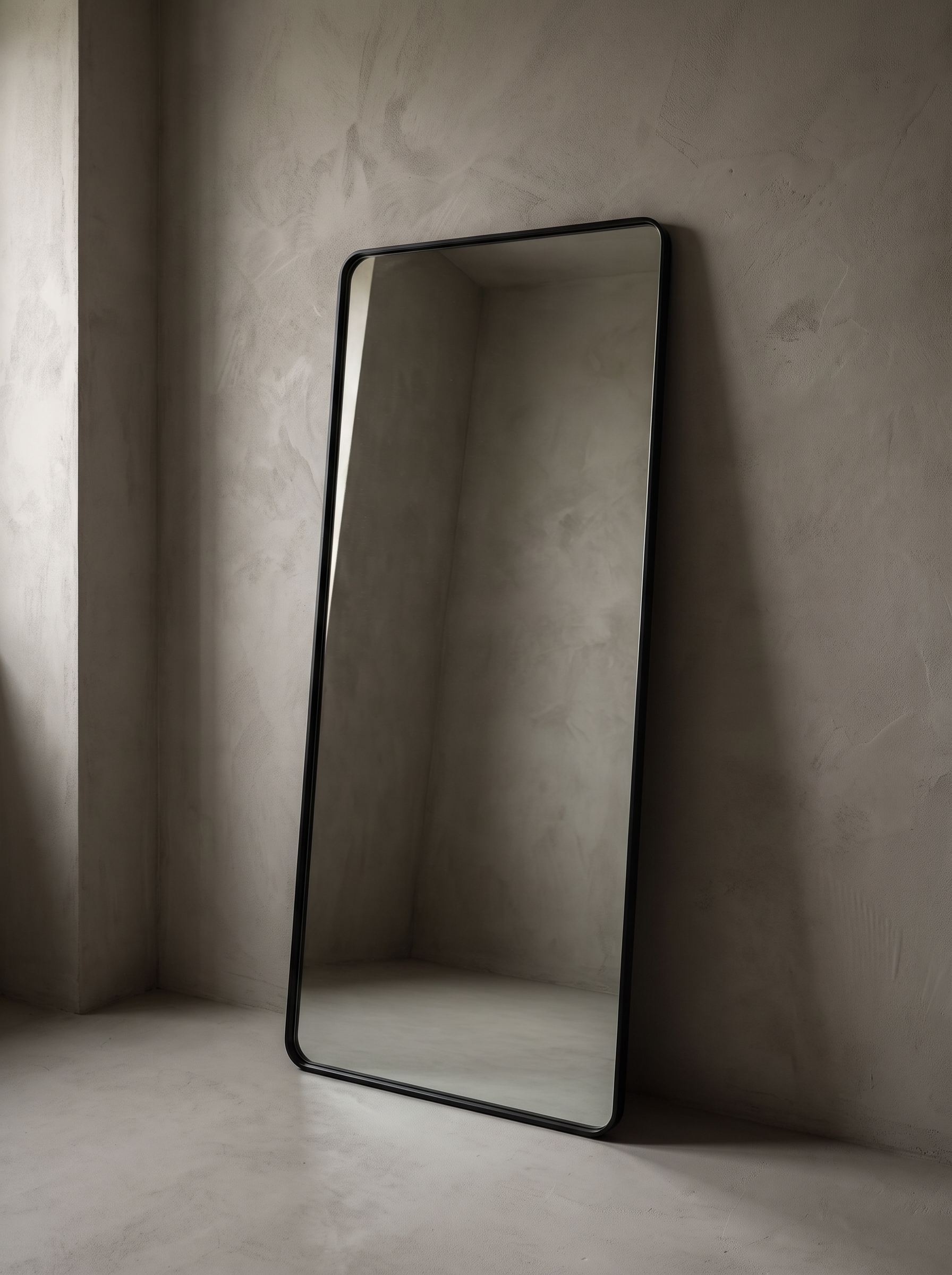 Three-quarter view of the large leaning floor mirror showing the rounded black metal frame